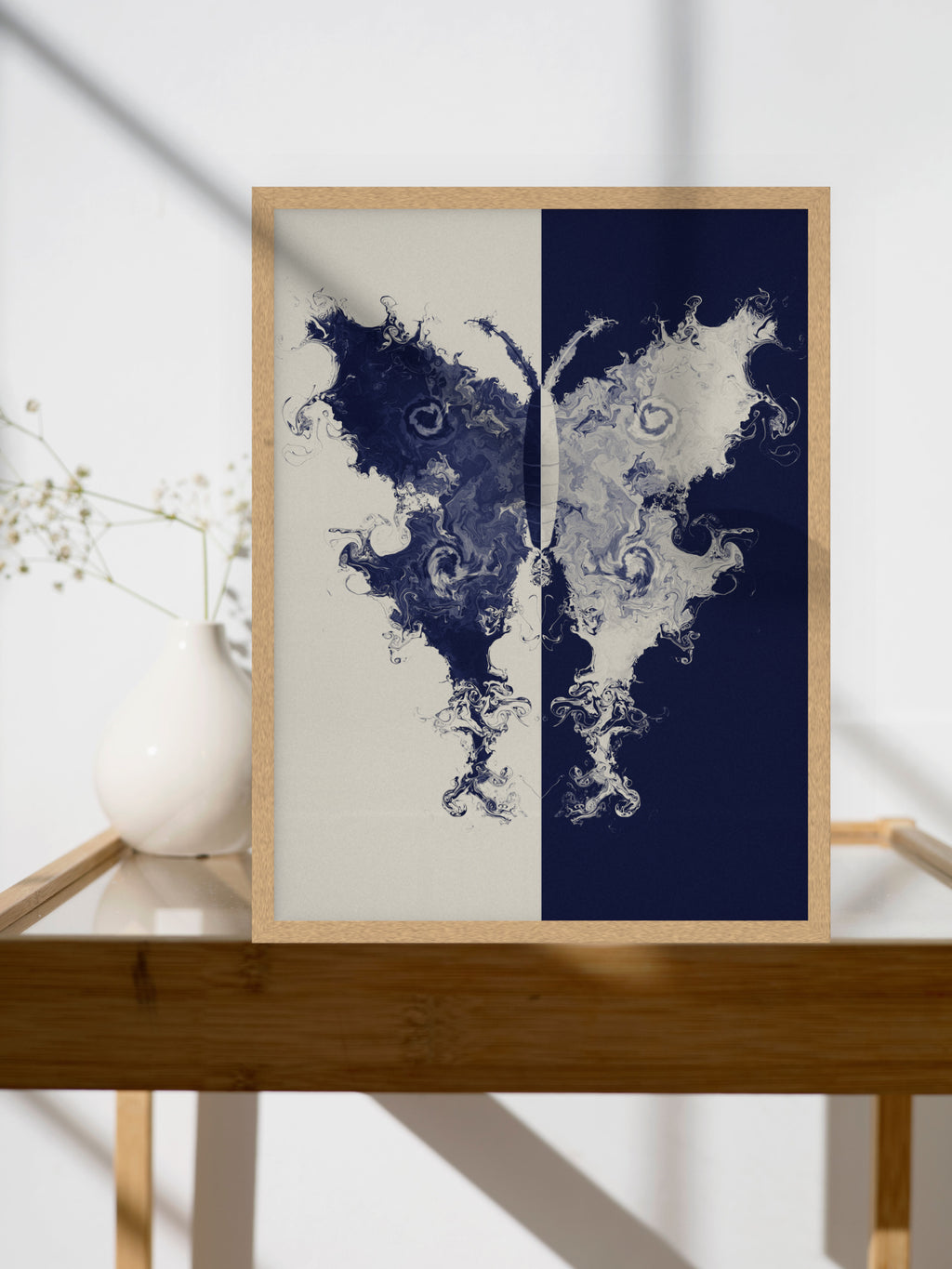 The Fold moth ink blot art print, cream and indigo study wall art, shown above a side table