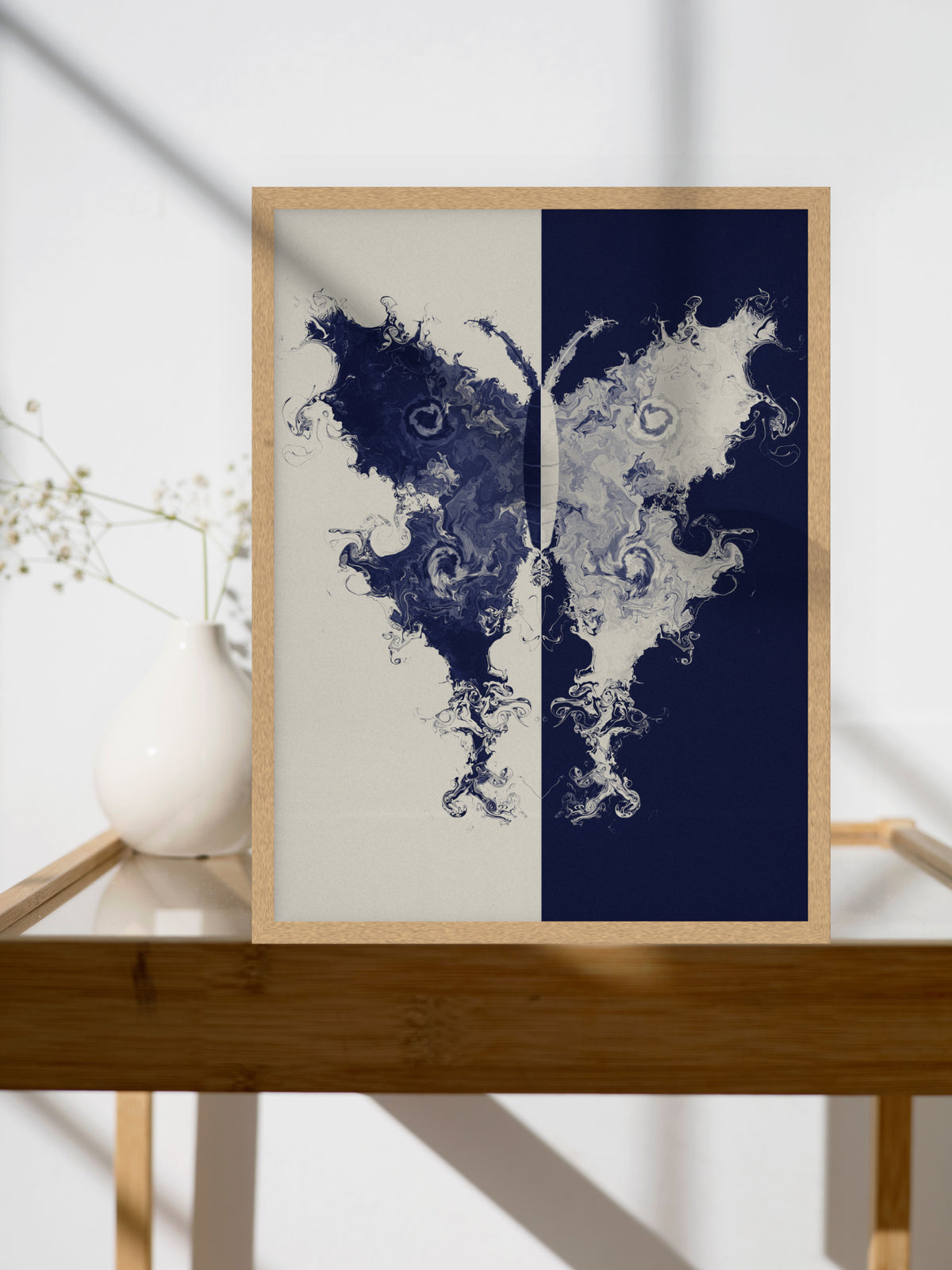 The Fold moth ink blot art print, cream and indigo study wall art, shown above a side table