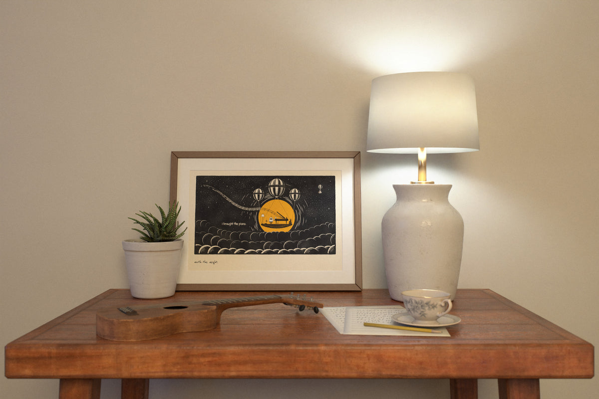 Worth the Weight piano poster in 12x18 above a composer's desk by lamplight