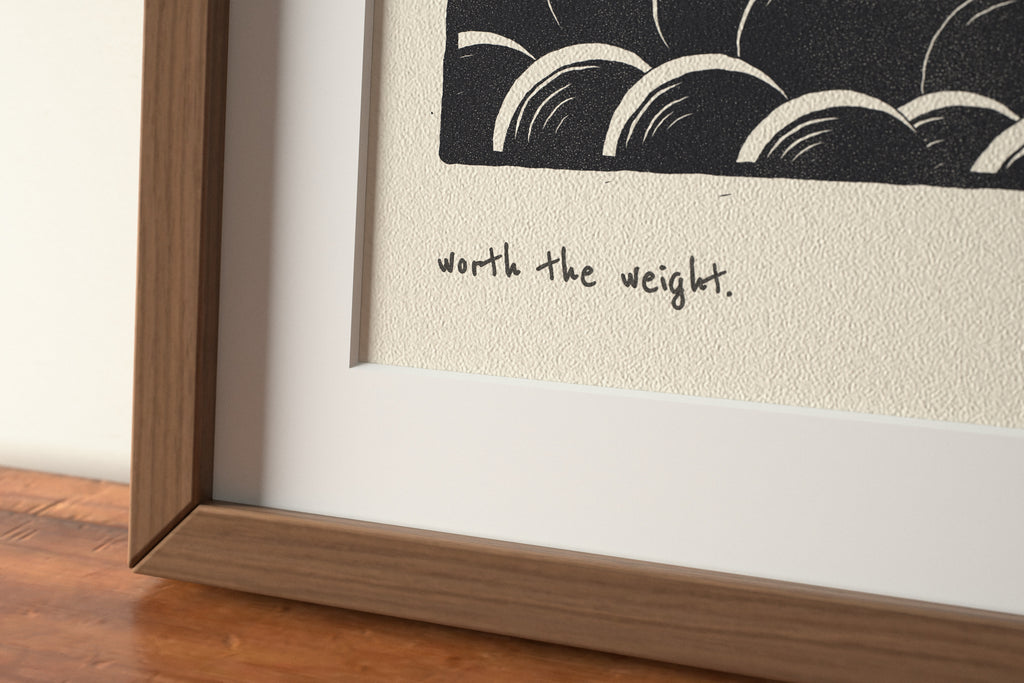 Close-up of the matte archival paper and handwritten caption on the Worth the Weight piano print