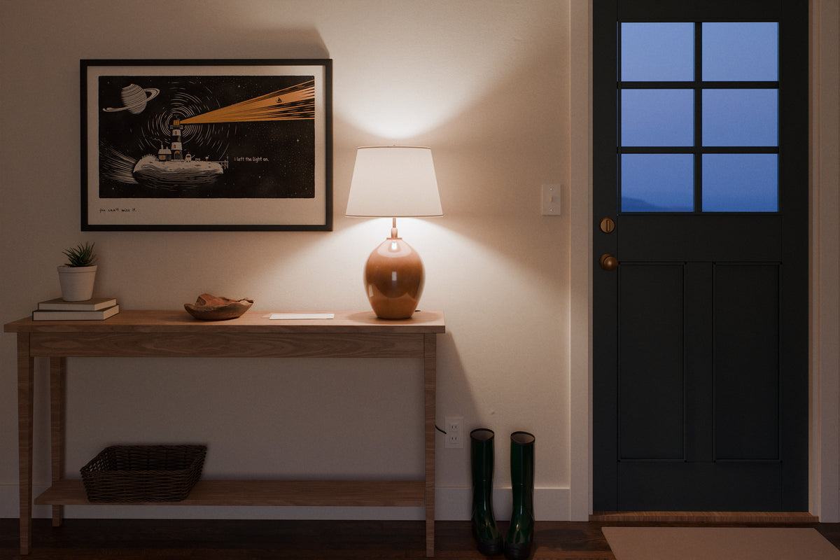 Robot lighthouse art print in 24x36, hanging in an entryway at dusk